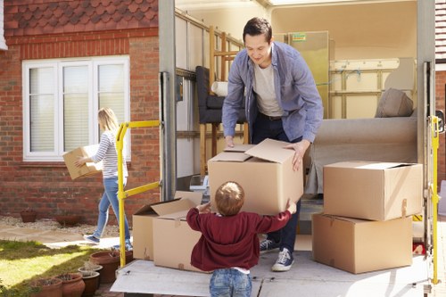Movers carrying a sofa through a residential property in Finchley